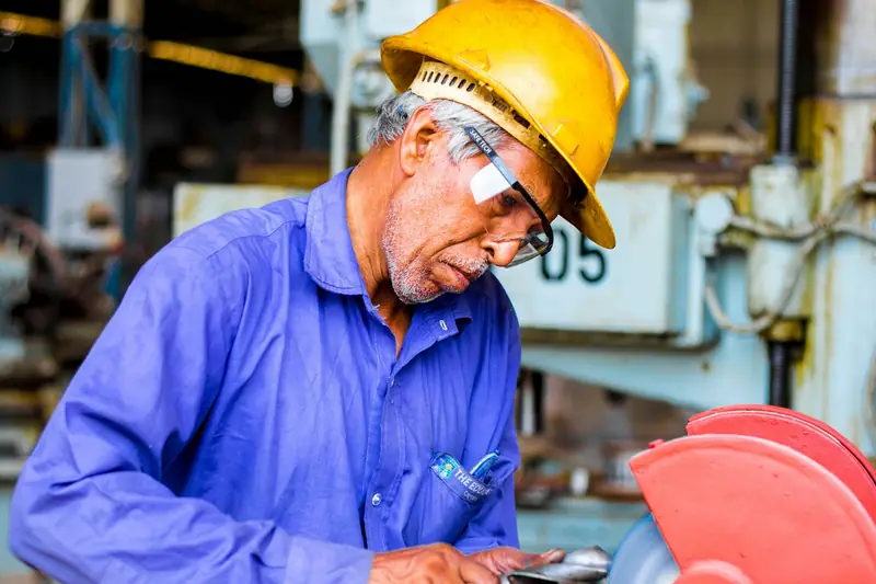 Machinist grinding a metal part